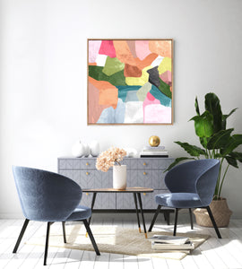 Colourful abstract canvas print in a timber look float frame hanging on the wall in a room mock up setting